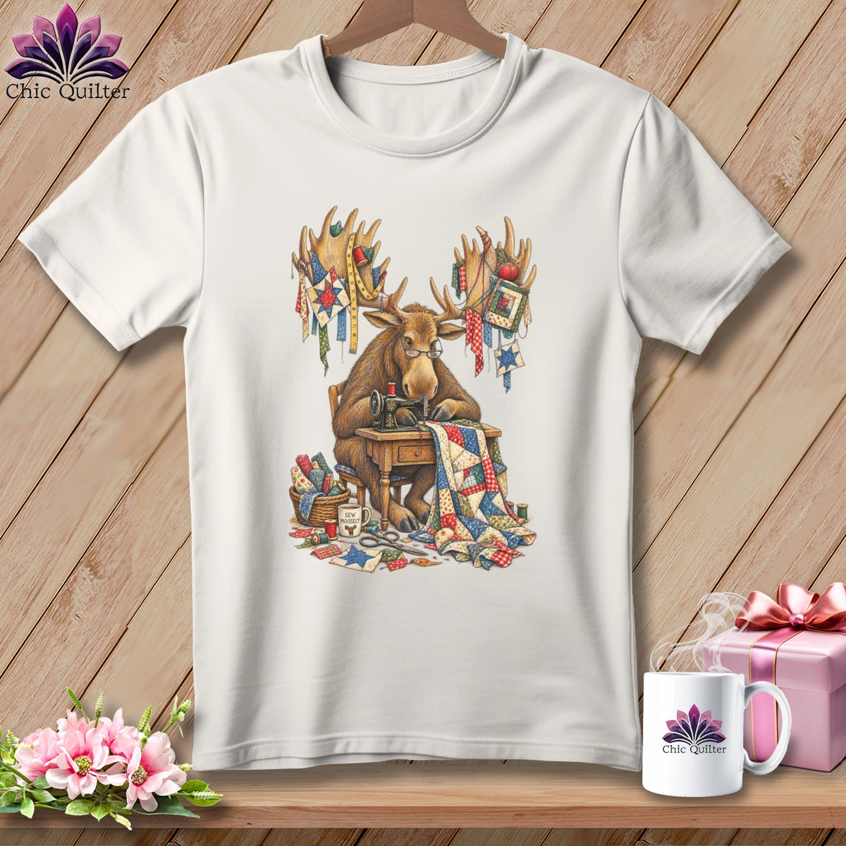 Moose at sewing machine with quilt and "Sew Moosey" mug on t-shirt.