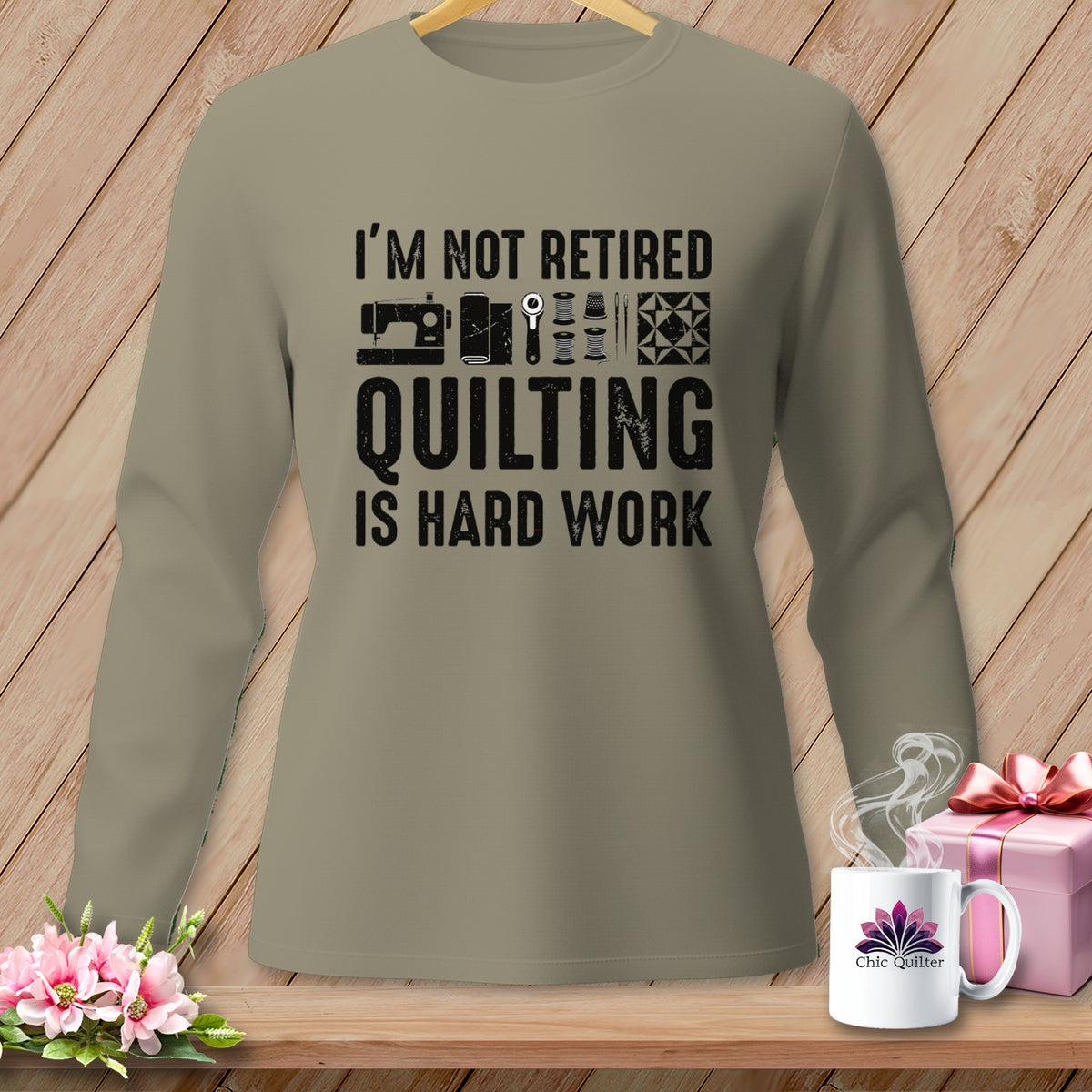 Long sleeve shirt with "I'm Not Retired Quilting Is Hard Work" text and sewing icons.