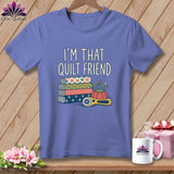 A purple t-shirt printed with the text I'm That Quilt Friend, stacked fabric, a pincushion, and a rotary cutter.