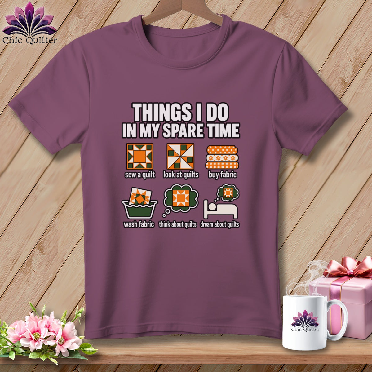 A plum-colored t-shirt on a wooden hanger with graphic text detailing quilting activities.