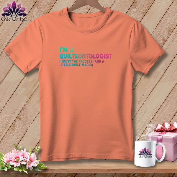Orange t-shirt with "I'm a Quilteontologist" text and floral logo.