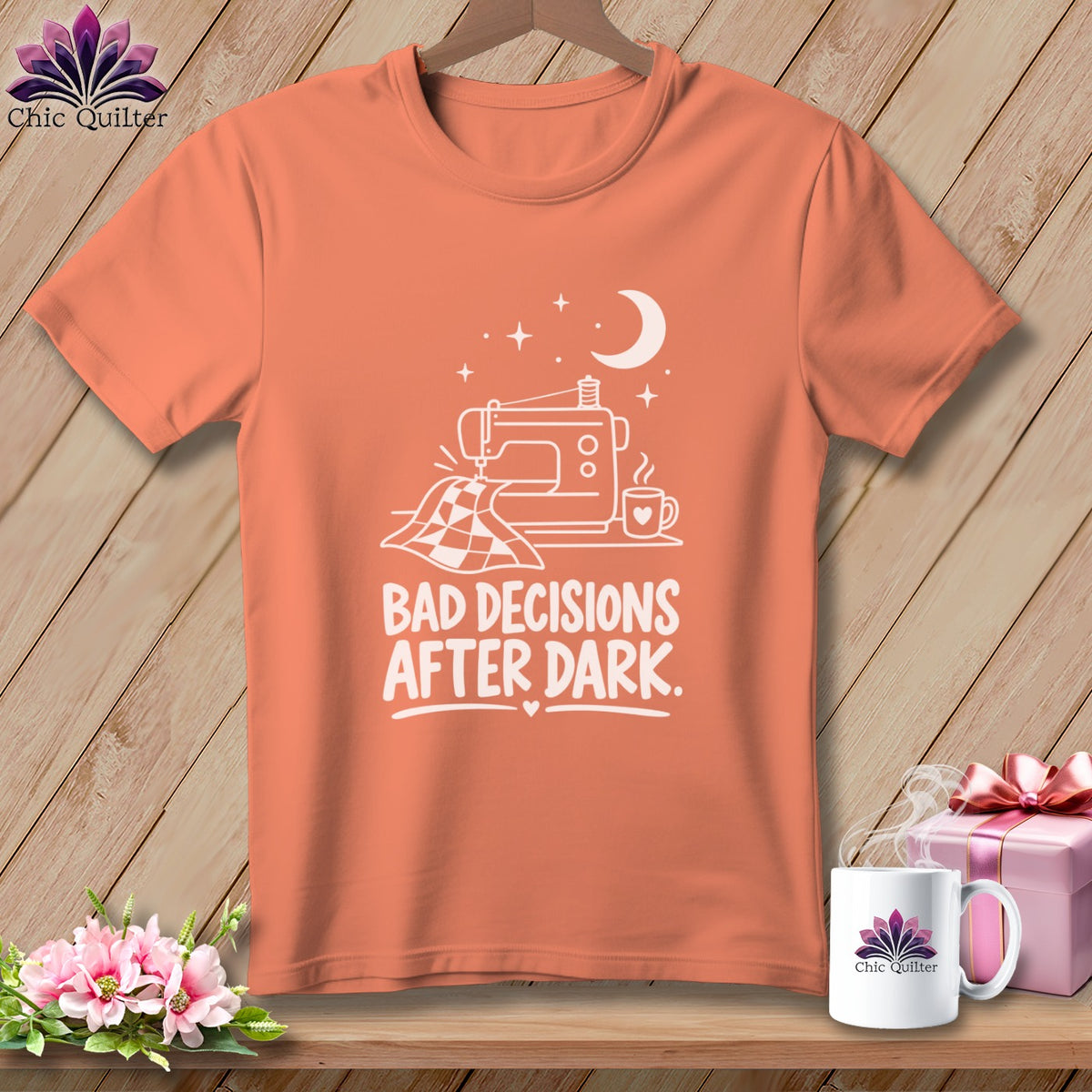 Peach t-shirt with white graphic of sewing machine, quilt, and text "BAD DECISIONS AFTER DARK."