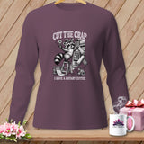 T-shirt with a raccoon holding a rotary cutter and fabric, with text 