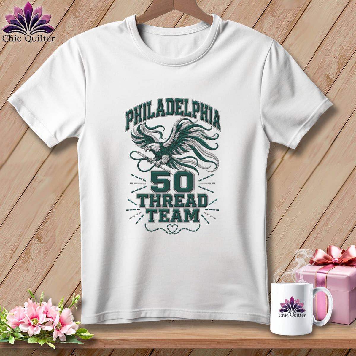 White t-shirt with a green graphic featuring an eagle, the text PHILADELPHIA 50 THREAD TEAM, and a needle.