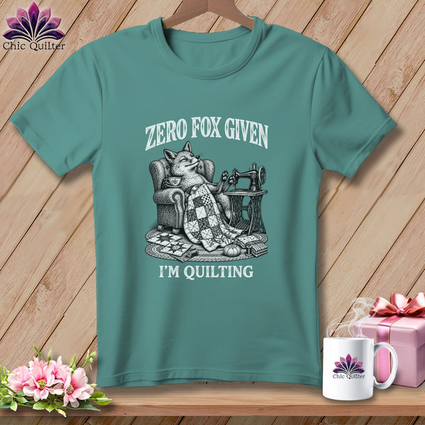 T-shirt with a fox relaxing in a chair with a quilt and sewing machine.