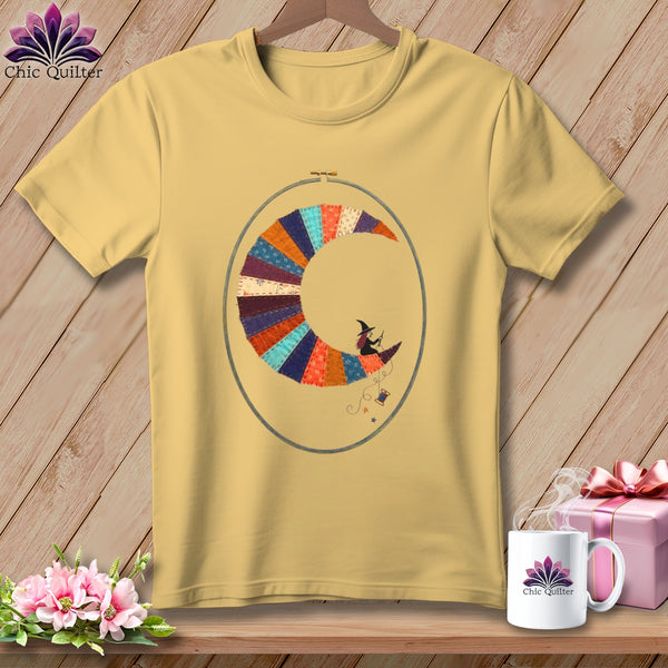 Yellow t-shirt with embroidered witch on crescent moon, sewing thread, and "Chic Quilter" logo.