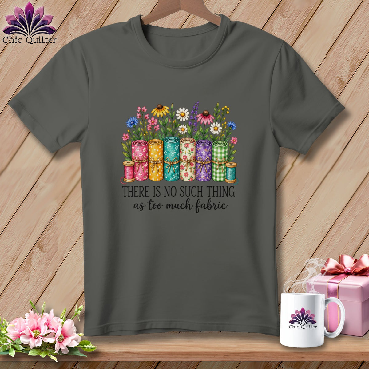 Dark gray t-shirt with a graphic of fabric rolls, flowers, and the text "There is no such thing as too much fabric."