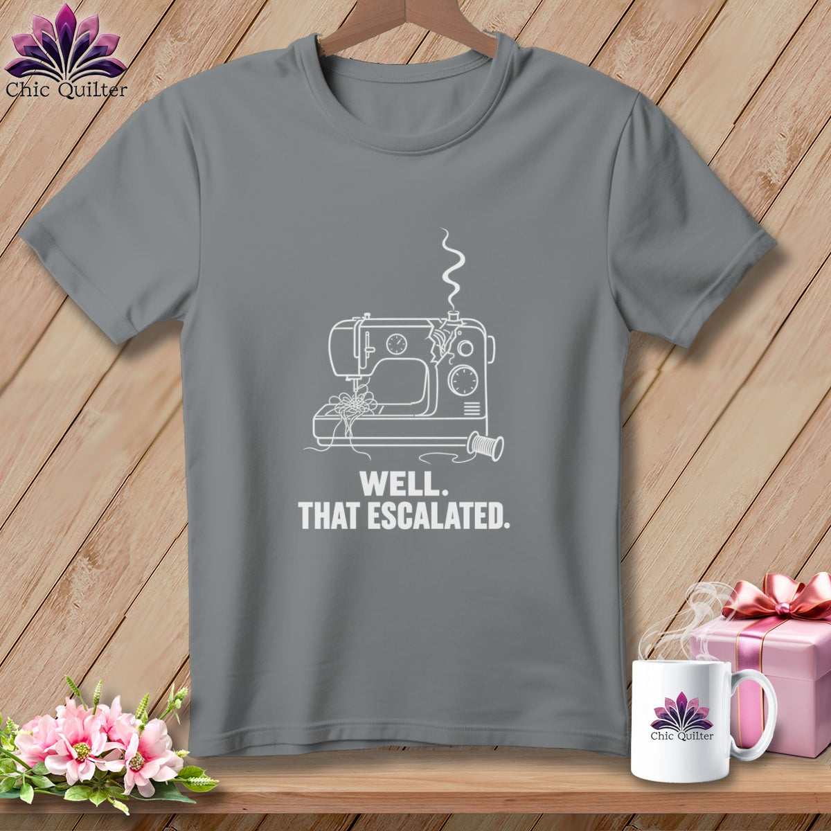 Gray t-shirt with white line drawing of a sewing machine and text: "WELL. THAT ESCALATED."