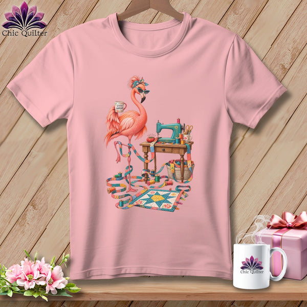 Pink t-shirt featuring a flamingo holding a "Stitch Happens" mug by a sewing machine.
