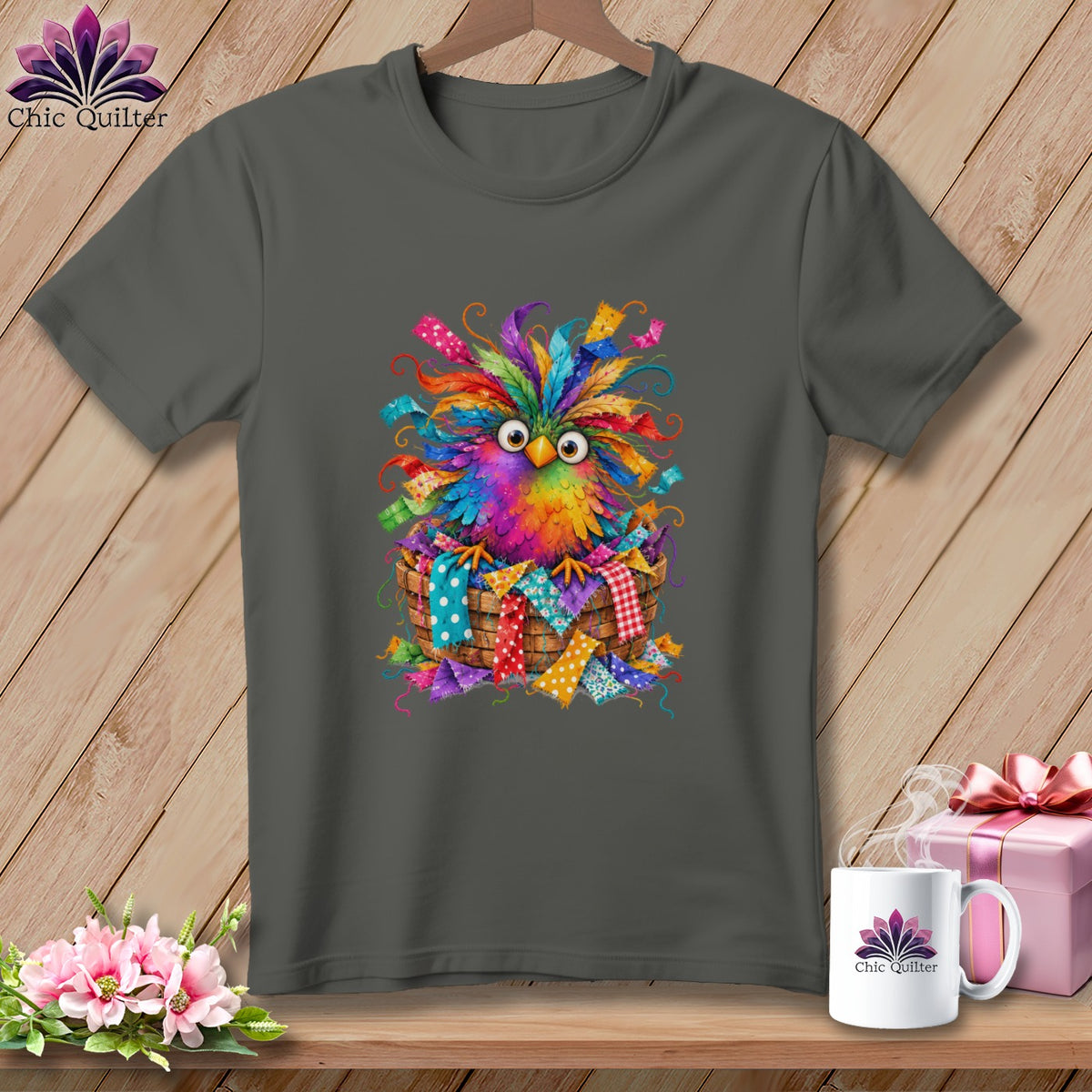 Dark gray t-shirt featuring a colorful, whimsical owl graphic sitting in a basket of fabric scraps.