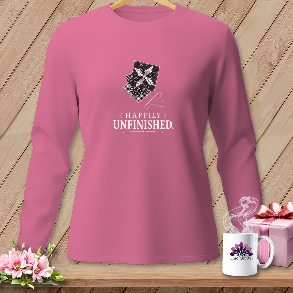 Pink long-sleeve shirt with "Happily Unfinished" and quilting designs.