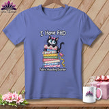 Periwinkle t-shirt on a hanger with a cartoon cat graphic and text reading I Have FHD Fabric Hoarding Disorder.
