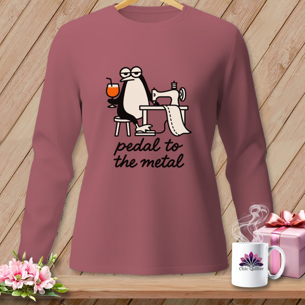 Long sleeve shirt with a penguin using a sewing machine and the text "pedal to the metal".