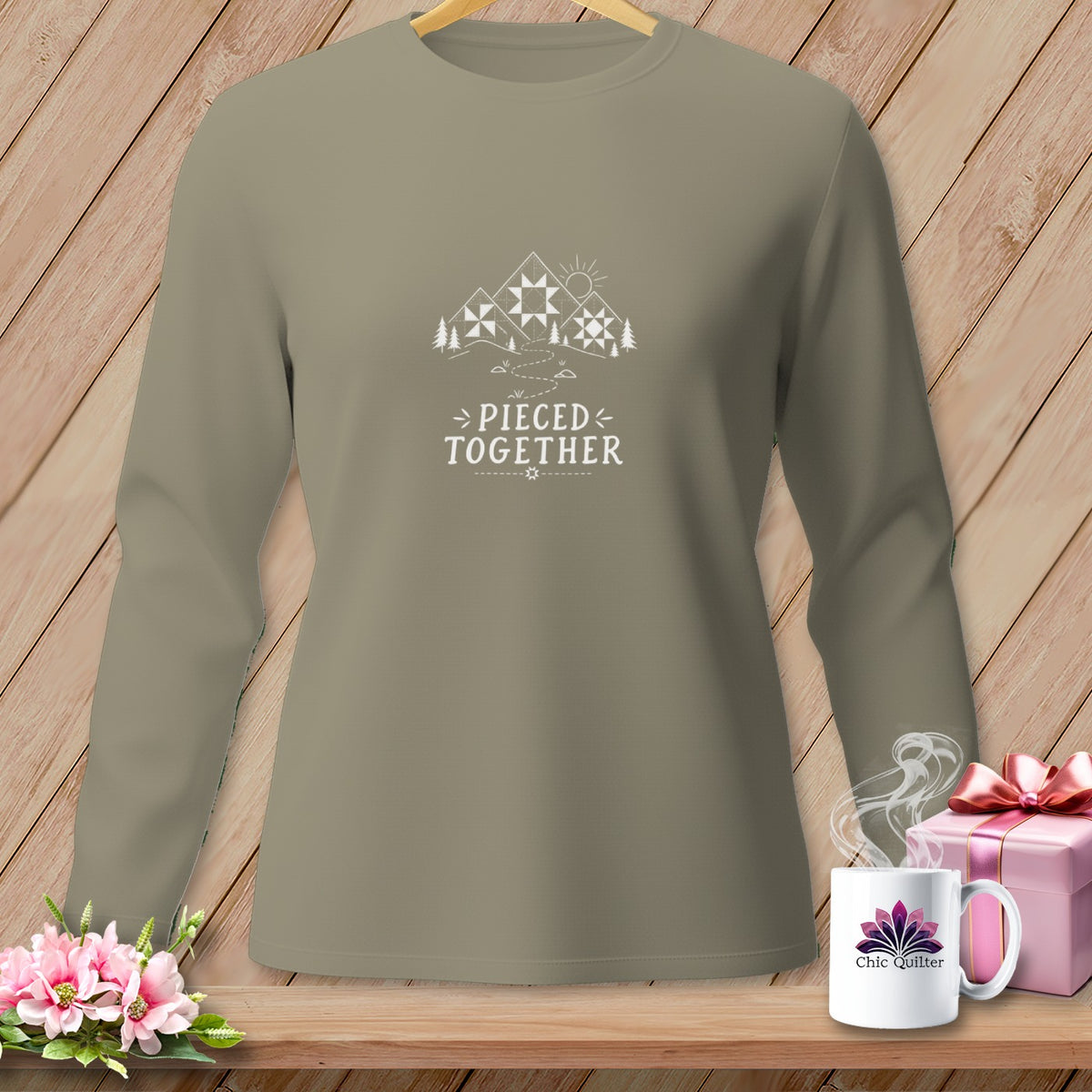 Long-sleeve shirt with "Pieced Together" text and mountain quilt graphic.