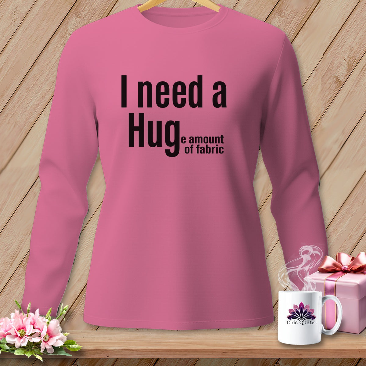 Pink long-sleeve shirt with "I need a Hug e amount of fabric" text.