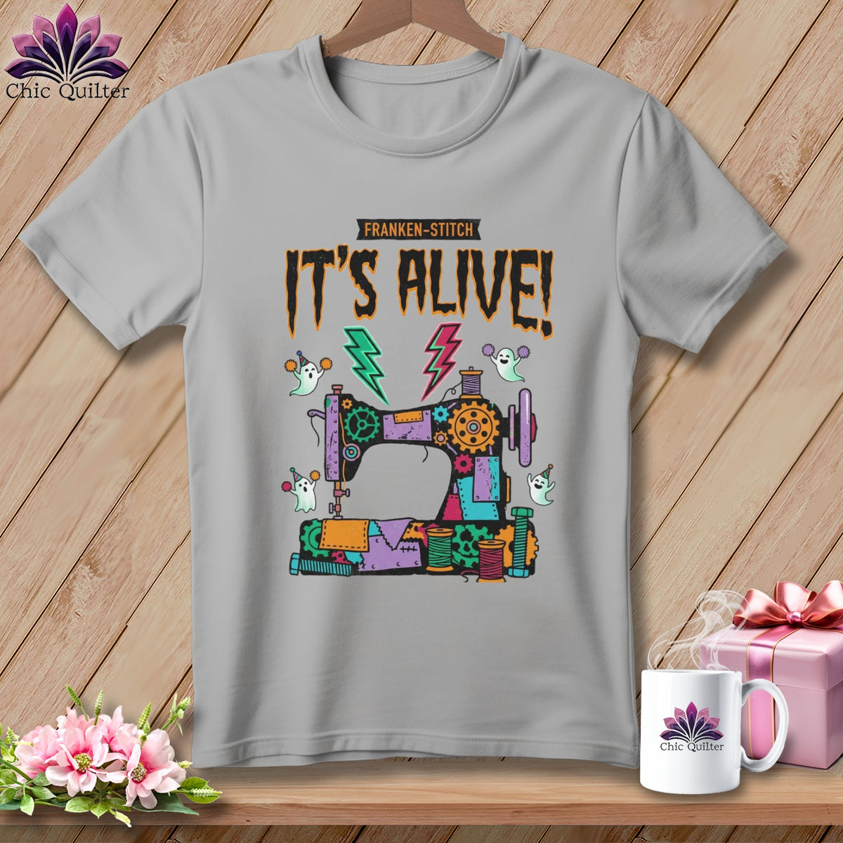"Franken-Stitch It's Alive!" text with a sewing machine, ghosts, and lightning bolts graphic on a t-shirt.