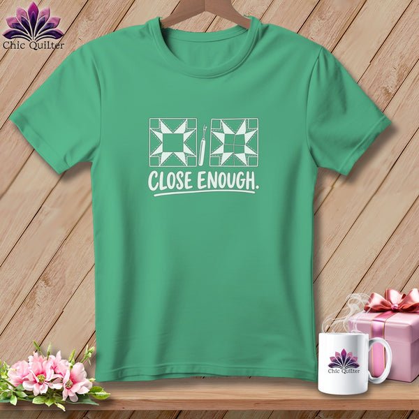 Green t-shirt with quilting blocks, seam ripper, and "CLOSE ENOUGH." text.