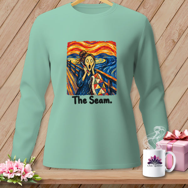 Mint green long-sleeve shirt with "The Seam." and a screaming figure holding a quilt.