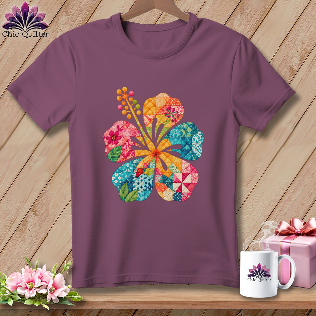 A purple crewneck t-shirt featuring a colorful patchwork hibiscus flower graphic on a wooden background.