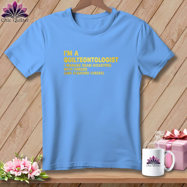 Light blue t-shirt with yellow text reading "I'm a Quilteontologist" and further description.