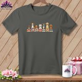 A dark gray t-shirt featuring a line of illustrated dogs sitting atop colorful stacked quilts.