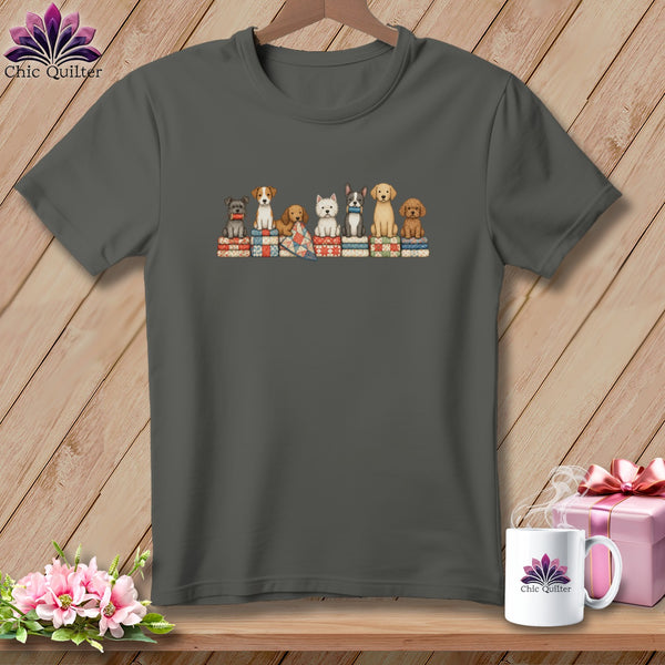 A dark gray t-shirt featuring a line of illustrated dogs sitting atop colorful stacked quilts.