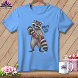 Light blue t-shirt with raccoon holding colorful patchwork tail, text 