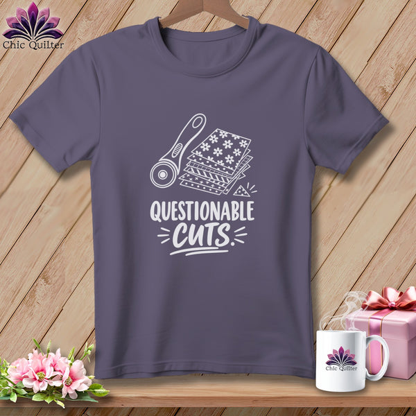 Purple t-shirt with a rotary cutter, fabric stacks, and the text "Questionable Cuts".