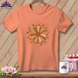 Peach t-shirt with a circular sewing motif of fabric patches, spools, and buttons.