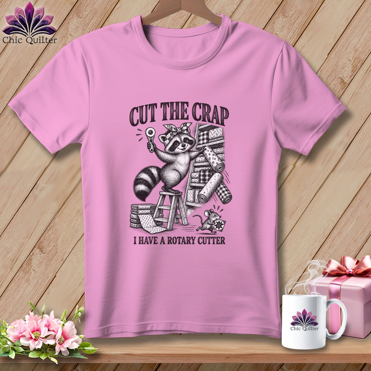 Pink t-shirt with a raccoon holding a rotary cutter and the text "CUT THE CRAP I HAVE A ROTARY CUTTER".