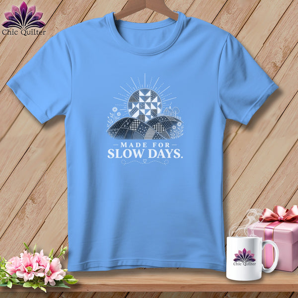 Light blue t-shirt with "Made for Slow Days" text and quilt-like sun graphic.
