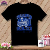 A black t-shirt with a blue graphic reading Indianapolis Quilter, featuring fabric bolts and a measuring tape.