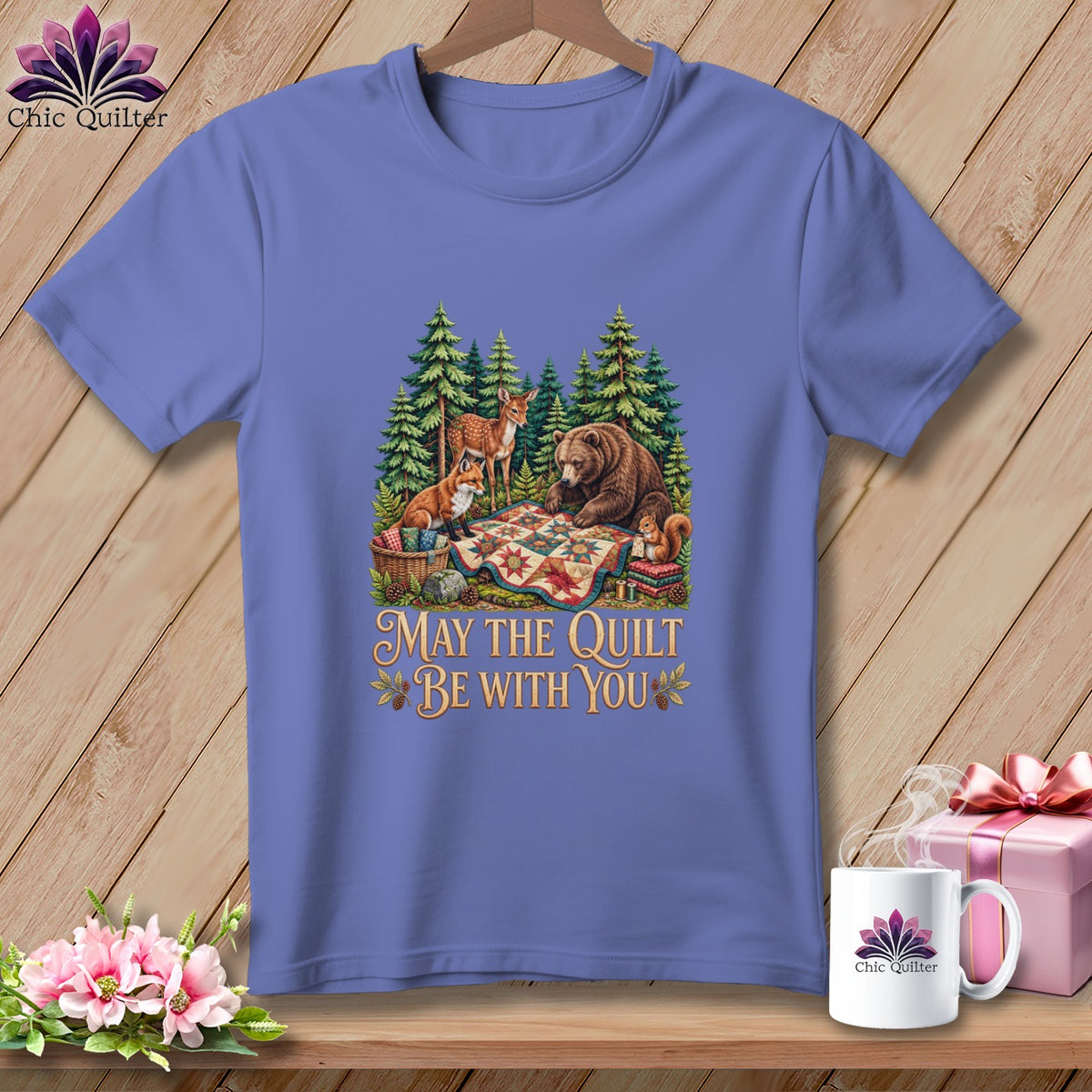 Periwinkle t-shirt featuring a forest graphic with woodland animals, a quilt, and the text "May the Quilt be with You".
