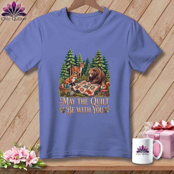 Periwinkle t-shirt featuring a forest graphic with woodland animals, a quilt, and the text "May the Quilt be with You".