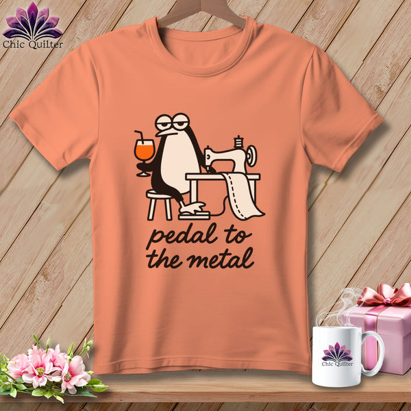 Peach t-shirt with penguin sewing and the text "pedal to the metal".