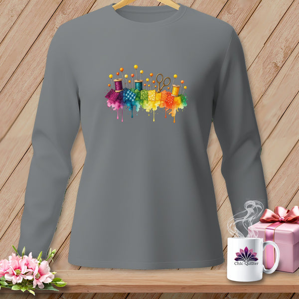 Gray long-sleeve shirt with colorful sewing notions and watercolor splashes graphic.