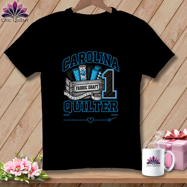 A black t-shirt features a blue and white quilting graphic with the text CAROLINA QUILTER and FABRIC DRAFT.