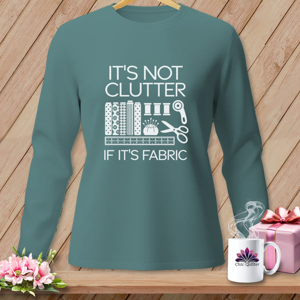 Teal long-sleeve shirt with white text "IT'S NOT CLUTTER IF IT'S FABRIC" and sewing icons.