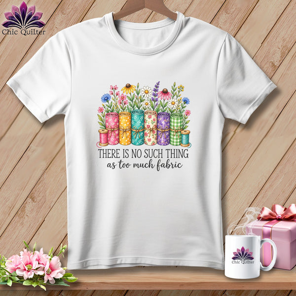 A white t-shirt features a watercolor illustration of tied fabric rolls and flowers with the text There Is No Such Thing As Too Much Fabric.