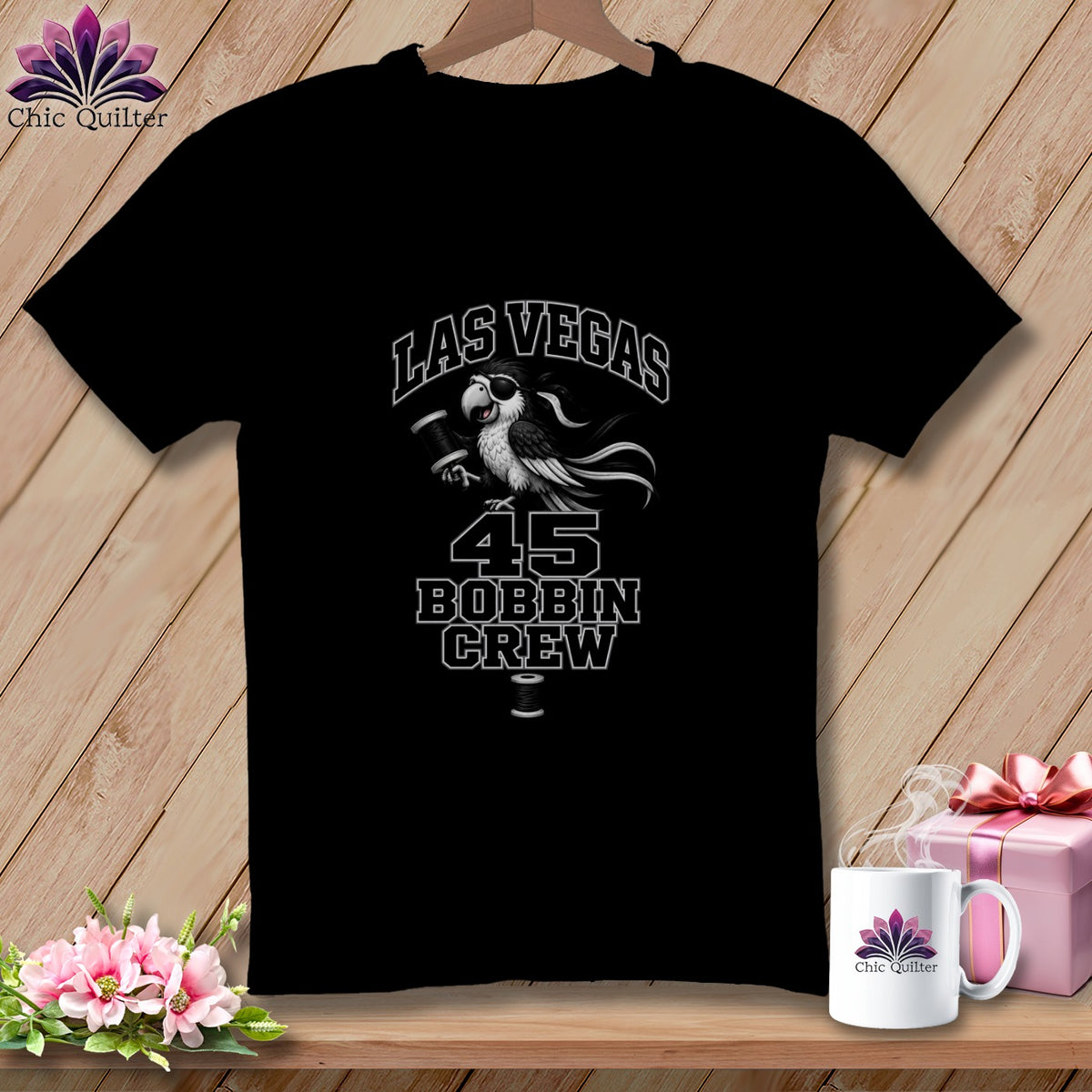 Black crewneck t-shirt with a graphic of a pirate parrot holding a thread bobbin, text reading "Las Vegas 45 Bobbin Crew".