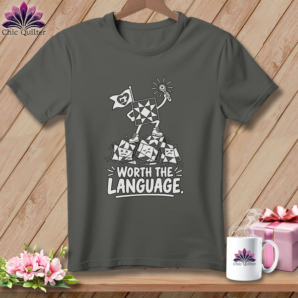 Dark grey t-shirt with quilting block character, flag, and text "WORTH THE LANGUAGE."