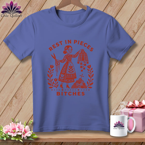 Purple t-shirt with orange graphic: "Rest in Pieces Bitches" surrounded by floral wreath.
