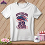 A white t-shirt on a wooden background features New England 99 Stash League graphics in red and blue.