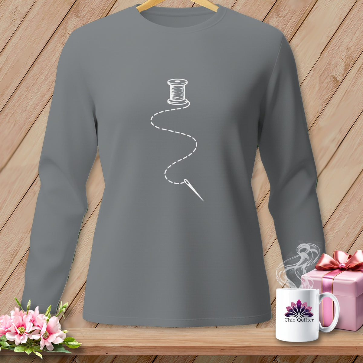 Grey long-sleeve shirt with a white spool of thread and needle graphic.