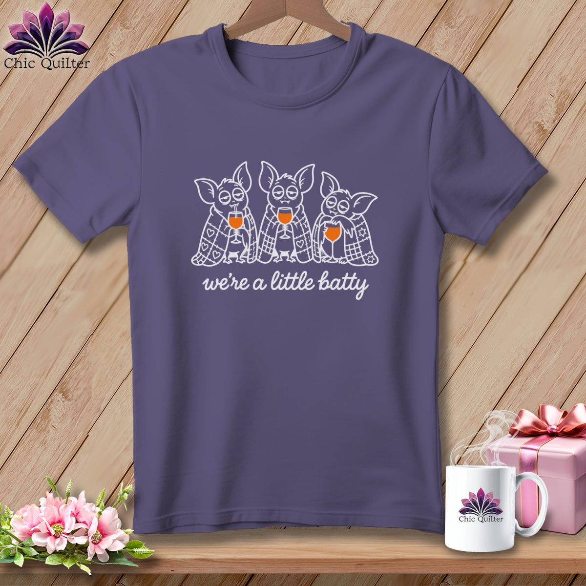 Purple t-shirt with three bats holding wine glasses and the text "we're a little batty".
