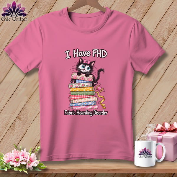 Pink t-shirt with a graphic of a black cat on a stack of fabric and text reading I Have FHD Fabric Hoarding Disorder.