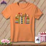 Orange crewneck t-shirt featuring a graphic of colorful stacked books and flowers on a wooden background.