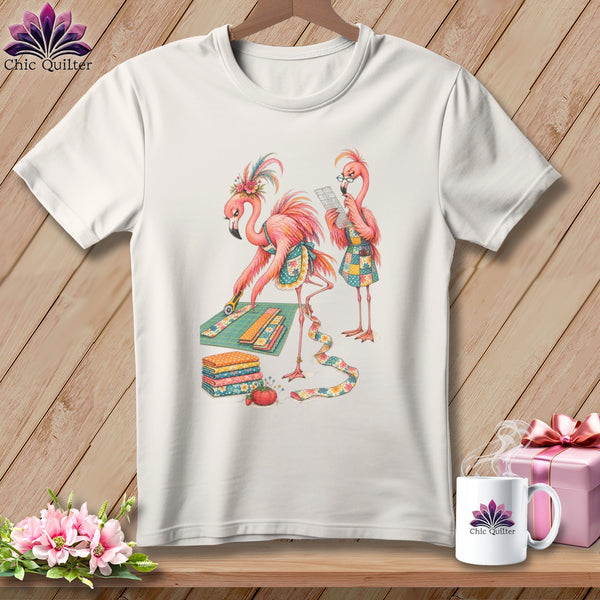 White t-shirt with two flamingos sewing fabric and quilting supplies.