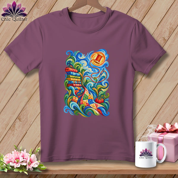 Mauve crewneck t-shirt featuring a vibrant, swirling graphic of quilting supplies on a wooden background.