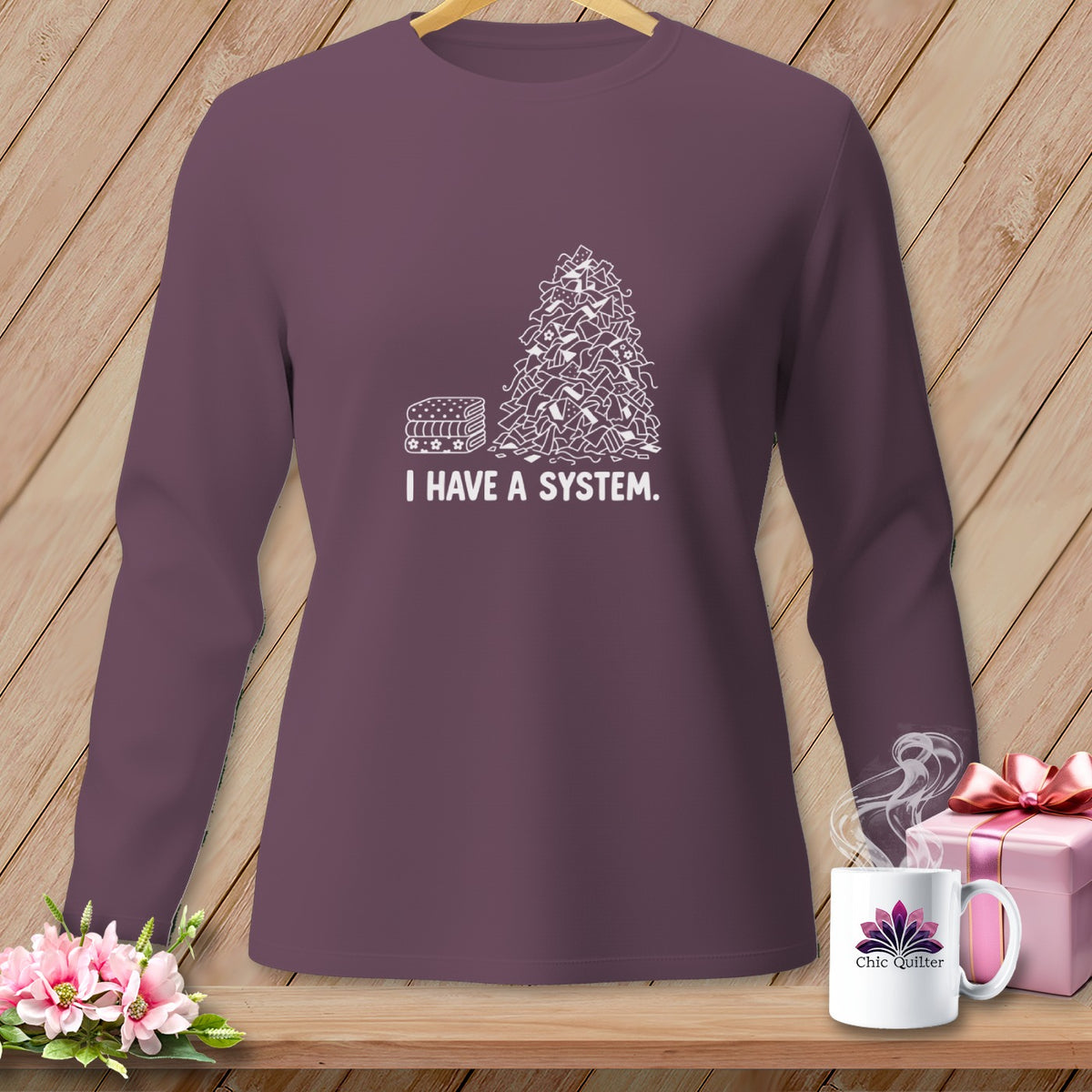 Purple long-sleeve shirt with "I HAVE A SYSTEM." text and quilting fabric pile graphic.